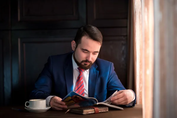 Молодий бізнесмен в журналі читання кафе Ліцензійні Стокові Зображення