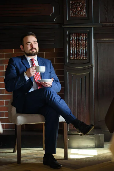 Reicher erfolgreicher schöner Mann im Anzug, der Kaffee trinkt — Stockfoto