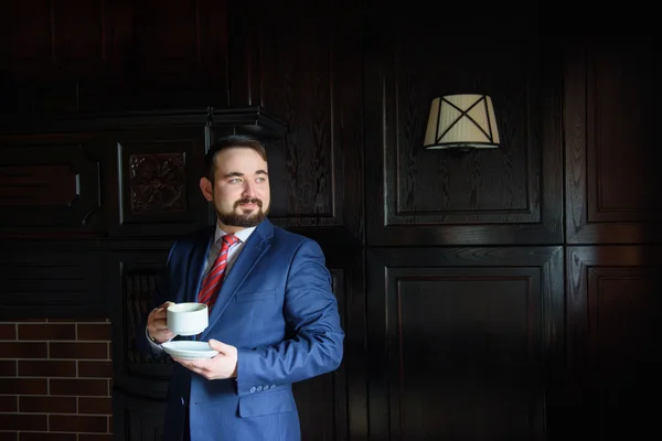 Багатий успішний красивий чоловік у костюмі п'є каву Стокова Картинка