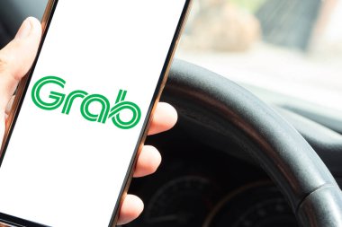 Bogota, Kolombiya - 23 Şubat 2026: Sürücü sürüş sırasında akıllı telefon, Asya ulaşım ve servis platformunda Yakala uygulamasını kullanıyor