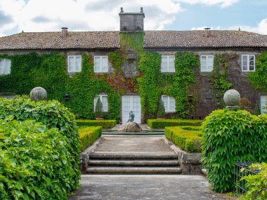 Tırmanan bitkiler güzel malikanenin ön cephesinde büyür. Pazo de Pegullal. Salceda de Caselas (İspanya)