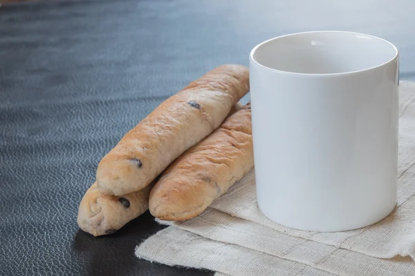 Raisin bread and coffee cup on fabric
