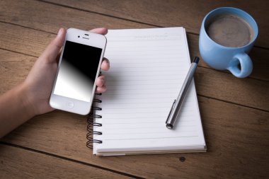 Akıllı telefon, cep telefonu, tablet, defter ve kahve fincanı kullanarak.