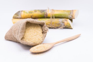 Kahverengi şekeri kaşık içinde şeker kamışının arka planında kapat