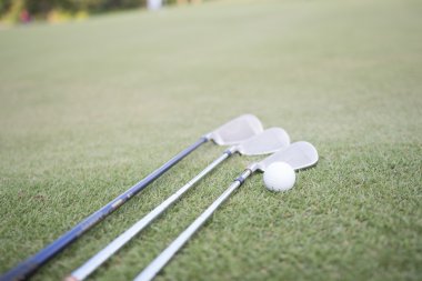 Golf topu ve yeşil çimenlerin üzerinde golf club