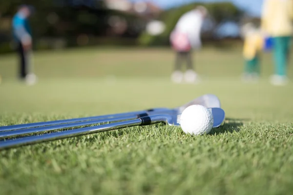 Bola de golf y club de golf en césped verde — Foto de Stock