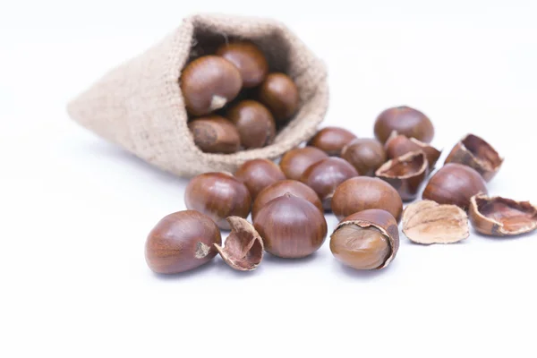 Castanhas frescas em yute isolado em branco — Fotografia de Stock