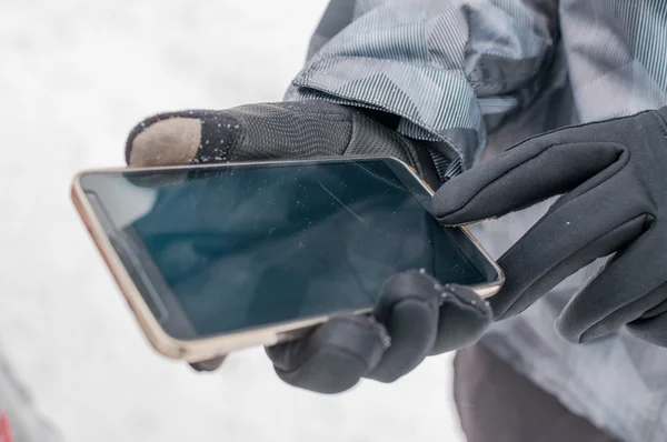 Man uses smartphone in winter — Zdjęcie stockowe