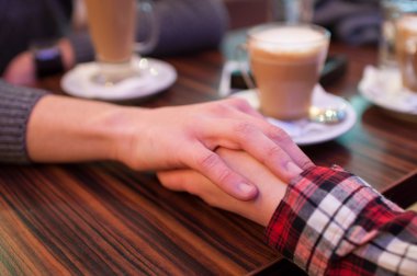 Kafede el ele tutuşarak Çift