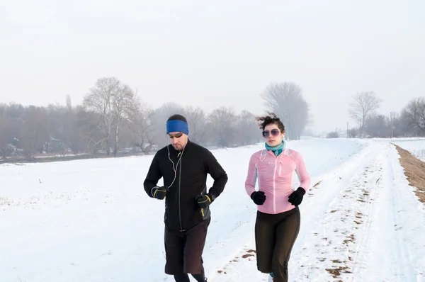 Mann und Frau rennen im Schnee — Stockfoto
