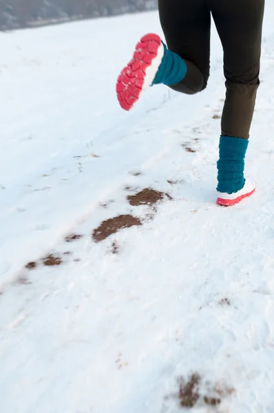 Femme courant sur la neige — Photo