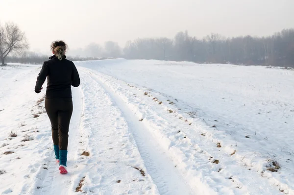 Femme courant sur la neige — Photo