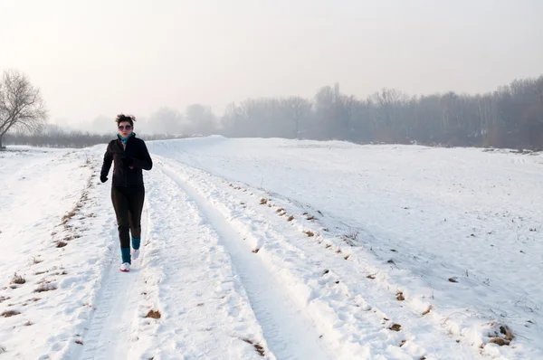 Femme courant sur la neige — Photo