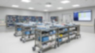 Modern, sterile medical supply room with carts & technology.