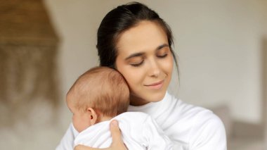 Mutlu genç anne kucaklaşması, evdeki rahat yatak odasında küçük çocuğuyla bağ kurması, boş yer. Annelik ve ebeveynlik konsepti