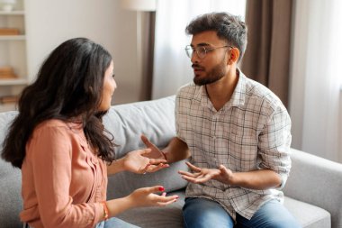 Hintli eşler ayrılık yaşıyor, ilişkilerde kriz yaşıyor, kanepede oturuyor ve birbirlerine bağırıyorlar.