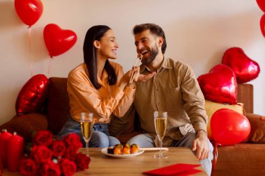 Çift evde kalp şeklinde balonlarla vakit geçirir, birbirlerine suşi ve kahkaha atarlar, yıldönümlerini ya da sevgililer günlerini kutlarlar.