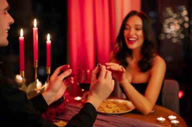 Evet dedi. Sevgililer Günü 'nde restoranda romantik bir ortamda nişan yüzüğü takan bir adam.