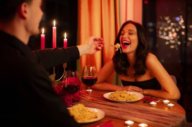 Sevgili çift restoranda romantik bir akşam yemeği yerken bir adam sevgilisine makarna yedirip Sevgililer Günü 'nü kutluyor. Aşk ve bakım konsepti