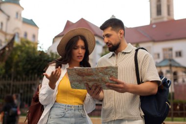 Tarihi kenti keşfederken kaybolan turistler haritayı inceliyor, erkek ve kadın bir sonraki yerlerinden emin değil gibi görünüyor.