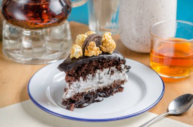 Çikolatalı vejetaryen pastası ve beyaz krema. Çikolatalı kurabiye ve karamelli patlamış mısırlı kek dekoru..