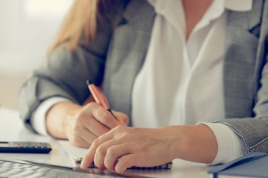 Finansal veri elde çalışan bir iş kadını. Hesap makinesi ve kalem kullanıyor. İş mali ve muhasebe kavramı.