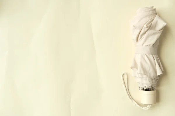 Şemsiye sarı bir arka plan üzerinde sağ tarafında katlanmış