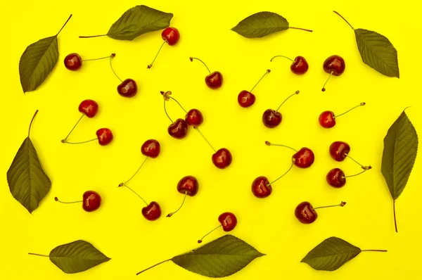 stock image Cherry Cherries with leaves on yellow background