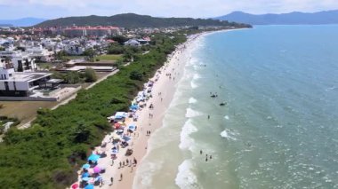 Florianopolis, Santa Catarina 'daki Jurere Uluslararası plajının havadan görünüşü, lüks evler, sahil kulüpleri, güneşli bir günde turkuaz mavi denizde lüks bir turistik bölgede lüks okyanus kıyısında konutlar..