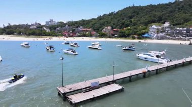 Florianpolis Santa Catarina 'daki Jurer Internacional, Tradicional ve Canajur plajlarının havadan görünüşü marina ve iskeleli turkuaz mavi denizde tekne, yat ve yelkenli tekneler..
