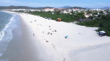 Florianpolis, Santa Catarina 'daki Jurere Internacional plajı, lüks evler, sahil kulüpleri, güneşli bir günde turkuaz mavisi deniz üzerinde lüks bir turistik sahilde lüks okyanus manzaralı evler..