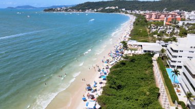 Florianpolis, Santa Catarina 'daki Jurere Internacional plajı, lüks evler, sahil kulüpleri, güneşli bir günde turkuaz mavisi deniz üzerinde lüks bir turistik sahilde lüks okyanus manzaralı evler..