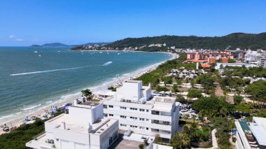 Florianpolis, Santa Catarina 'daki Jurere Internacional plajı, lüks evler, sahil kulüpleri, güneşli bir günde turkuaz mavisi deniz üzerinde lüks bir turistik sahilde lüks okyanus manzaralı evler..