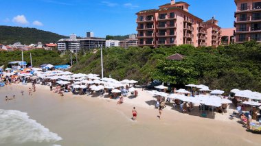 Florianopolis, Santa Catarina 'daki Jurere Uluslararası plajı, lüks evler, plaj kulüpleri, denize bakan lüks konutlar, kalabalık turist kumsalları ve şemsiyeler..