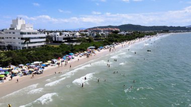 Florianopolis, Santa Catarina 'daki Jurere Uluslararası plajının havadan görünüşü, lüks evler, sahil kulüpleri, güneşli bir günde turkuaz mavi denizde lüks bir turistik bölgede lüks okyanus kıyısında konutlar..