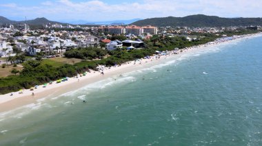 Florianopolis, Santa Catarina 'daki Jurere Uluslararası plajının havadan görünüşü, lüks evler, sahil kulüpleri, güneşli bir günde turkuaz mavi denizde lüks bir turistik bölgede lüks okyanus kıyısında konutlar..