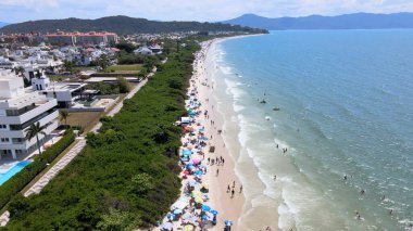 Florianopolis, Santa Catarina 'daki Jurere Uluslararası plajının havadan görünüşü, lüks evler, sahil kulüpleri, güneşli bir günde turkuaz mavi denizde lüks bir turistik bölgede lüks okyanus kıyısında konutlar..