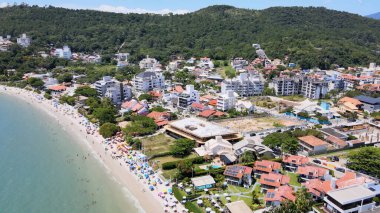 Florianopolis, Santa Catarina 'daki Jurere Uluslararası Sahili' nin panoramik hava manzarası. Lüks evler ve sahil kulüpleri deniz kenarında, tekneler, yatlar ve turkuvaz mavisi okyanusta yelkenliler..