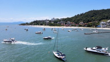 Florianopolis 'teki Canajure Sahili' nde tekneler, yatlar ve yelkenliler turkuaz mavi denizde marina ve rıhtımda..