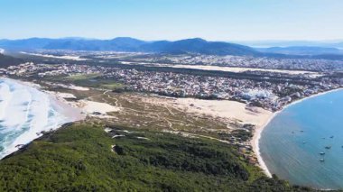 Florianpolis, Santa Catarina 'daki Santinho Sahili ve Ingleses Sahili' nin panoramik hava manzarası, güzel güneşli bir günde Ingleses Tepesi 'nin tepesinden görülen dinlenme alanı ve kumullar..