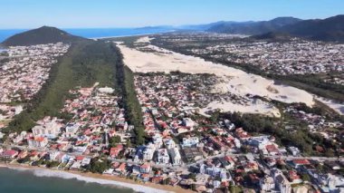 Florianpolis, Santa Catarina 'daki Ingleses plajının panoramik hava manzarası. Sahildeki bir şehir kompleksi, şehrin ana planı, mahalleler ve denize bakan gayrimenkul gelişmeleri..