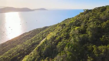 Florianpolis, Santa Catarina 'daki Ingleses sahilinin hava manzarası, dağlardan güzel bir günbatımı ve denizde balıkçı tekneleri ile görüldü..