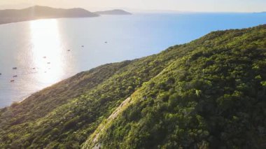 Florianpolis, Santa Catarina 'daki Ingleses sahilinin hava manzarası, dağlardan güzel bir günbatımı ve denizde balıkçı tekneleri ile görüldü..