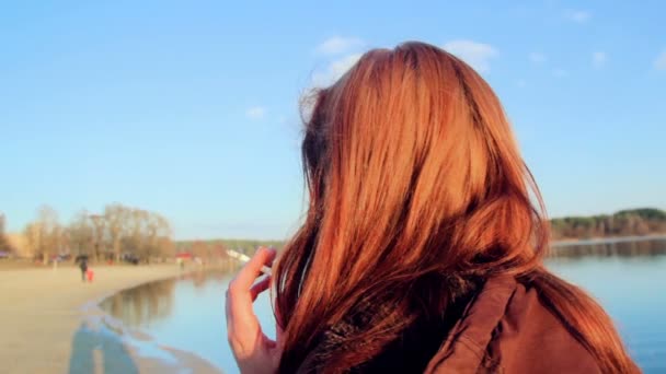 Girl smokes on the waterfront — Stock Video