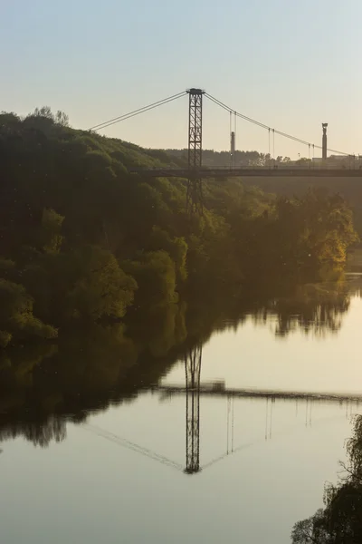 Silhueta de pessoas que viajam através da ponte — Fotografia de Stock