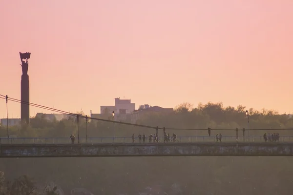 Silhouette de personnes voyageant à travers le pont — Photo