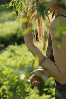 Genç kız gün batımıyla çayırda yürüyor..