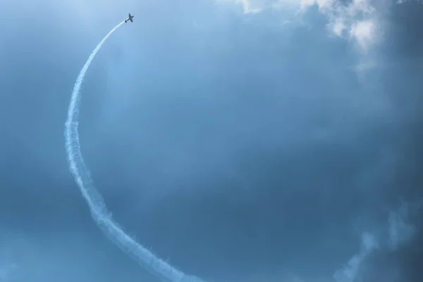 青い飛行機が白い雲と青い空に向かって飛んでいく — ストック写真