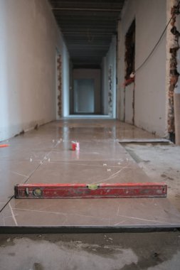 Kirli balon düzeyi aracı inşaat alanındaki beton duvar yatay kapanmasını kontrol ediyor.