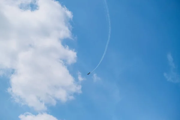 青い飛行機が白い雲と青い空に向かって飛んでいく — ストック写真